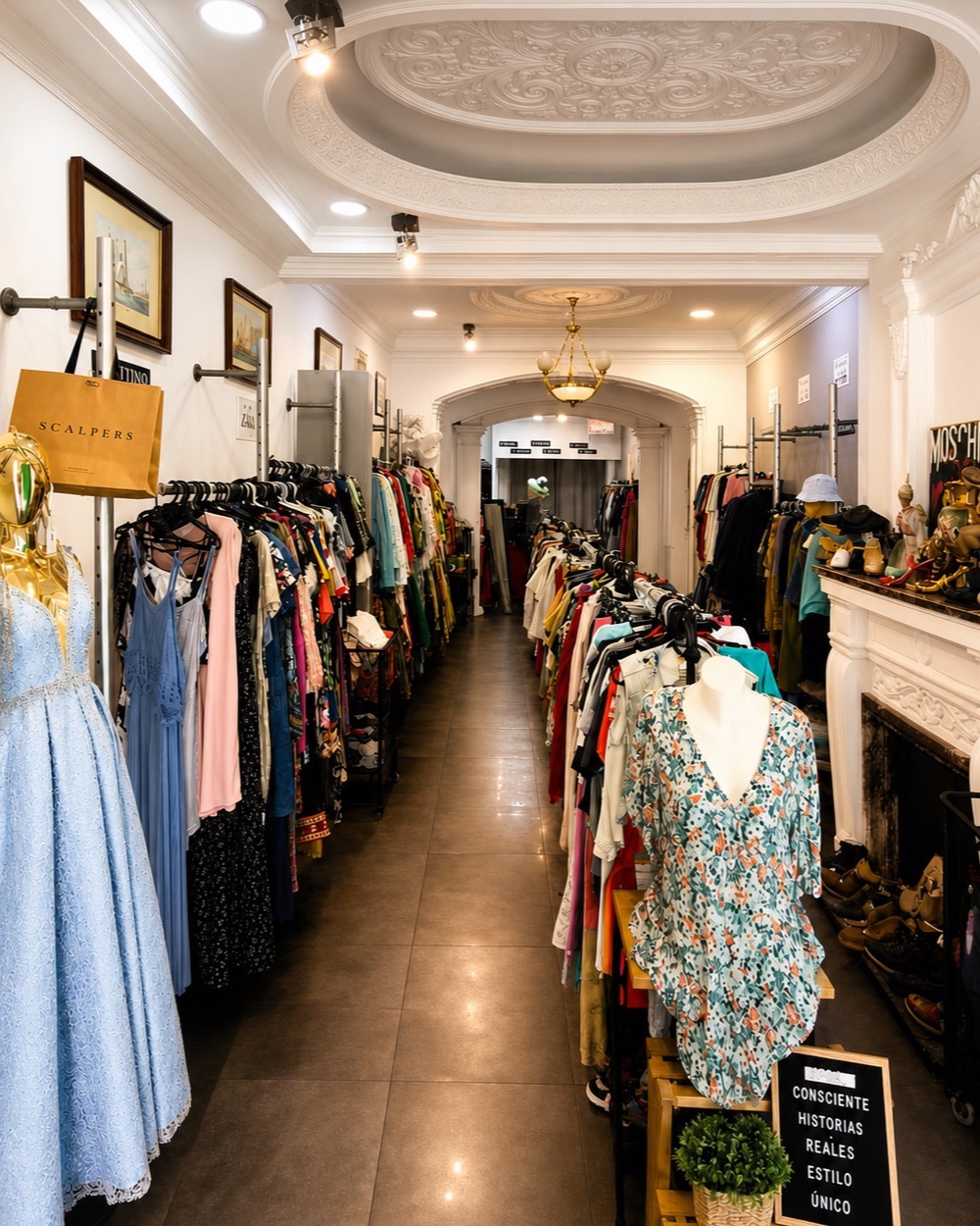 Interior de Ropa con Historia en Alzira, con prendas seleccionadas y detalles de la arquitectura original